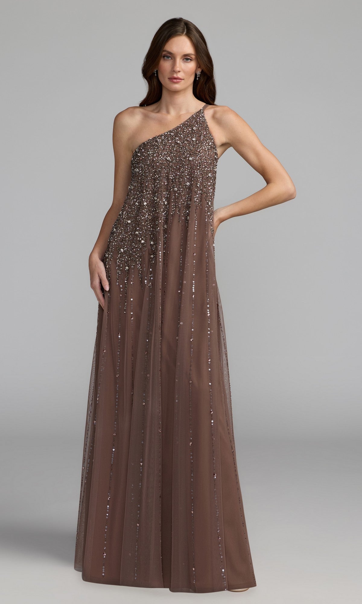 A woman models the Mac Duggal 9224, a one-shoulder, floor-length formal dress adorned with sequins, set against a plain gray background—ideal for special occasions.